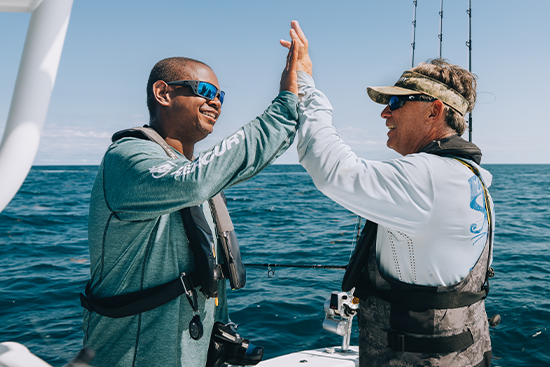 fishermen on boat high fiving