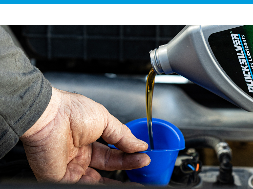 mechanic filling engine with quicksilver oil