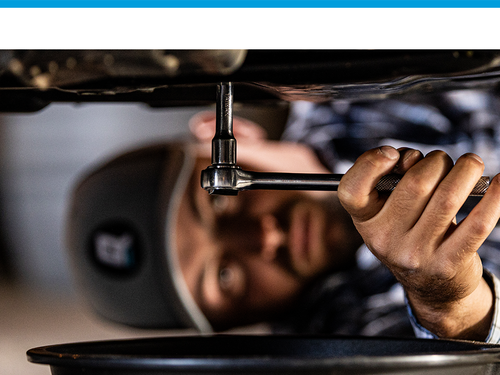 mechanic loosening drain plug