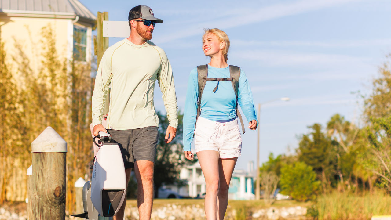 man and woman walking with avator outboard