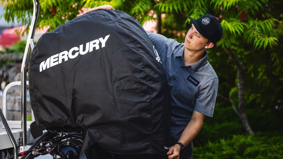 Man adjusting a cowl cover on a Mercury engine