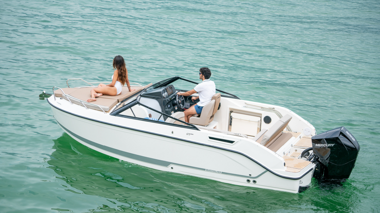 Frau auf einem Wakeboard hinter einem Boot
