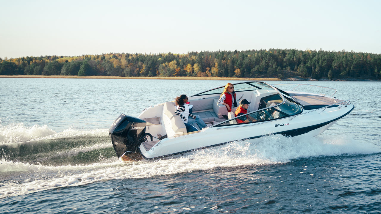 Frau auf einem Wakeboard hinter einem Boot