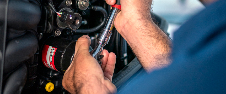 A mechanic working on an outboard motor