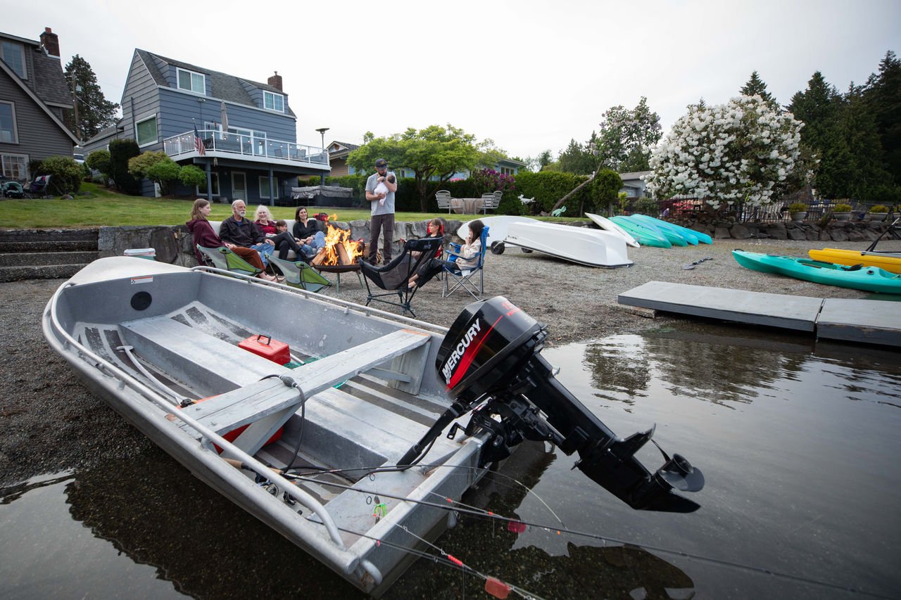 family near the water with Mercury powered boat