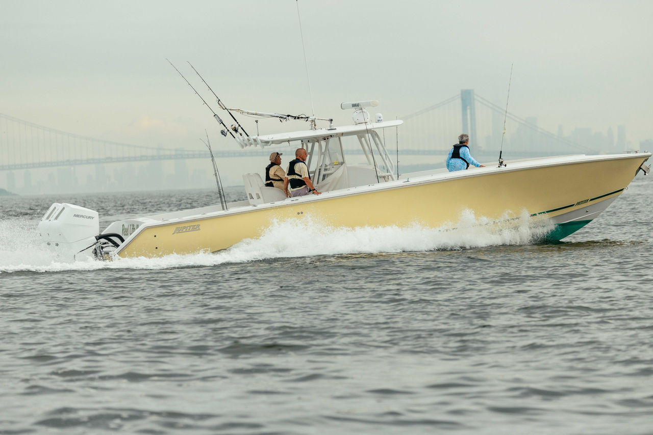 a recently repowered boat cruises in front of the Staten Island bridge