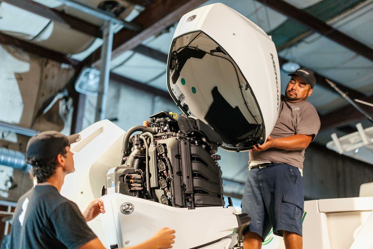 two technicians replacing the cowling on a Mercury V10 Verado